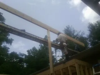 Carpenter setting a ridge beam over a new addition frame — Ice Dam Removal by Roofing Brothers in Pilot Mound