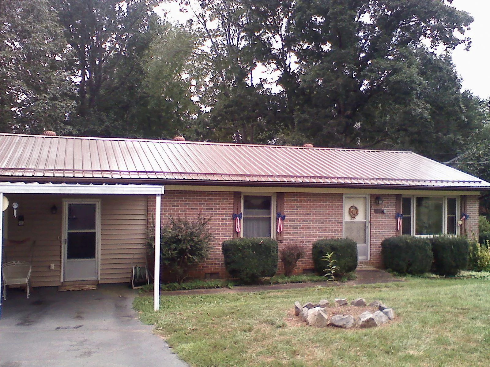 Bronze metal roof and carport on a brick ranch home — Roof Repair work by our crew in Pilot Mound